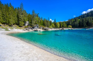 Cauma Gölü (Caumasee) körfezindeki cennet plajında kristal mavi su ve güzel dağ manzarası yer almaktadır.