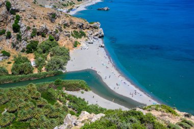 Preveli Sahili - güzel nehriyle ünlüdür açık mavi su ve plajın arkasındaki tropikal palmiye ormanıyla - güney Girit adasında, Yunanistan, Avrupa.