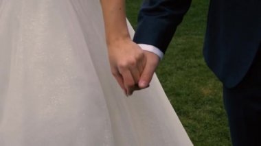 Erkek ve kadın el ele tutuşur, gelin ve damat, elleri yakın, sokak ve gün