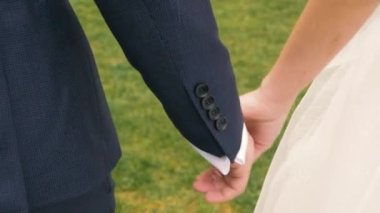 Erkek ve kadın el ele tutuşur, gelin ve damat, elleri yakın, sokak ve gün