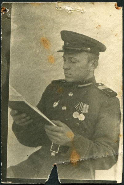 URSS - CIRCA 1949: Foto tomada en la URSS, se muestra leyendo a un sargento del Ejército Rojo, alrededor de 1949 — Foto de Stock