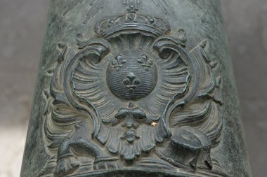 French coat of arms of King Louis XIV (Sun King) on the old bronze cannon. clipart