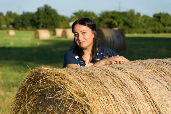 A woman and a stack of straw — Stock Photo, Image
