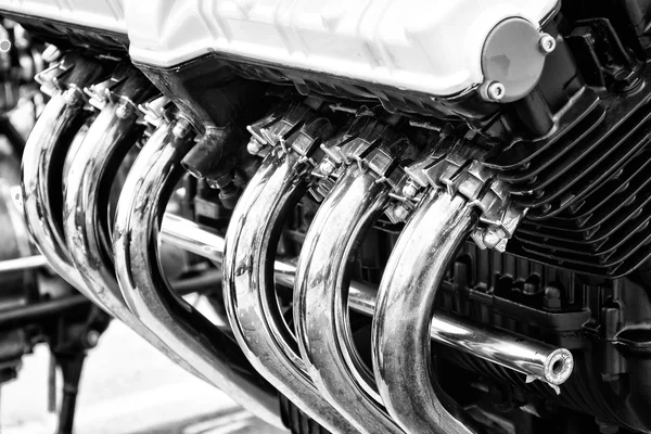 A fragment of a motorcycle exhaust pipe. Black and white. — Stock Photo, Image