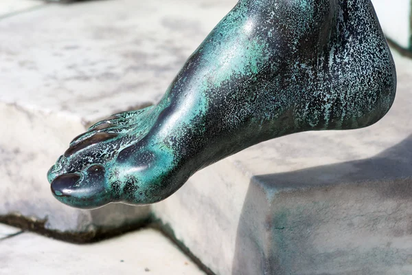 A bronz szobor töredéke közelről. láb. — Stock Fotó
