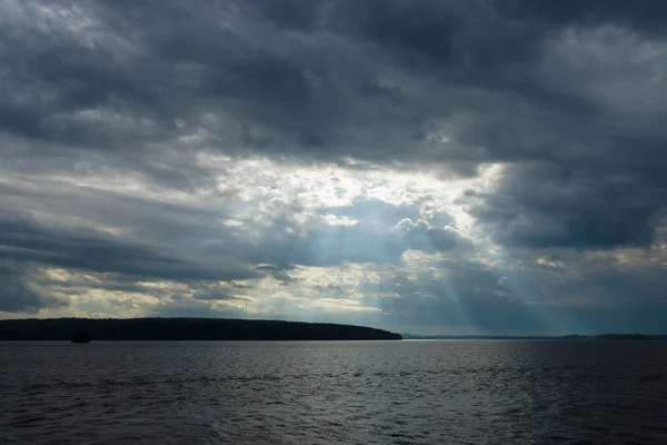 Cloudy sky over the lake. Rays of light through the clouds. — Stock Photo, Image