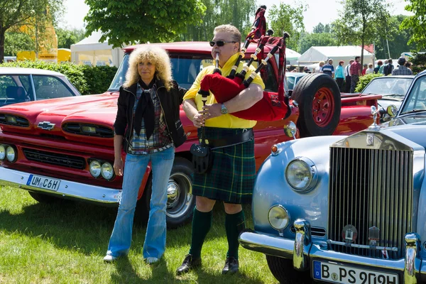 Paaren im glien, deutschland - 19. mai 2013 in paaren im glien, deutschland: piper spielt den großen highland dudelsack in der nähe des autos rolls-royce silver cloud, die oldtimer show im mafz, 19. mai 2013 in paaren im glien, deutschland — Stockfoto