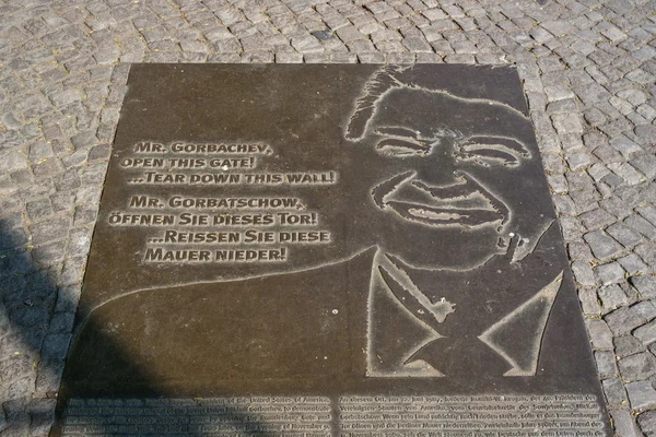 Мемориальная доска вместо Берлинской стены с фрагментом текста президента США Рональда Рейгана: "Господин Горбачев, откройте ворота! ... Снеси эту стену. !" — стоковое фото