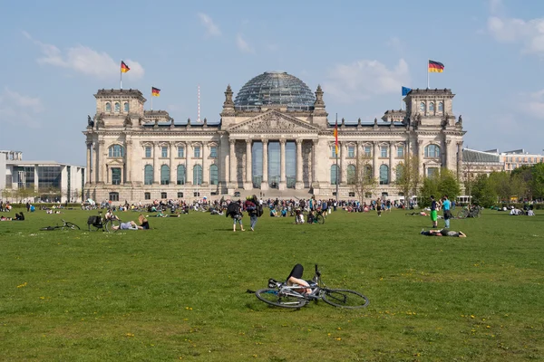 Il Reichstag bâtiment et vacanciers résidents et visiteurs sur le terrain. Le bâtiment du Reichstag est un édifice historique à Berlin . — Photo