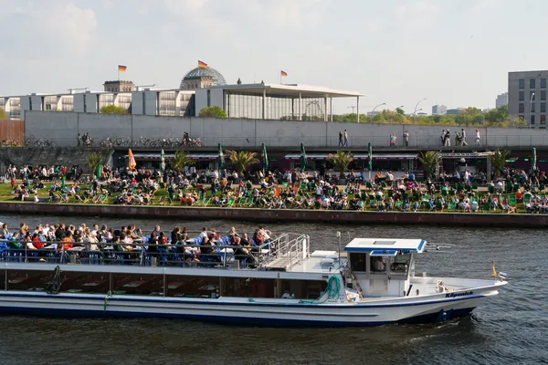 Restaurant sur le quai Spree et bateau de plaisance. Visiteurs de loisirs traditionnels et résidents de Berlin . — Photo