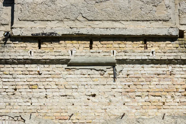 Oude bakstenen muur van het gebouw en afbrokkelende gips. — Stockfoto