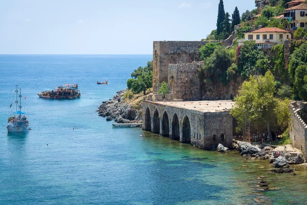 Shipyard (Tersane) and the ruins of a medieval fortress (Alanya Castle) on the mountainside. Alanya. Turkey. — Stock Photo, Image