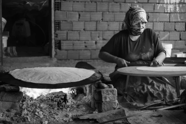 Village women prepare traditional flatbread on an open fire. Turkey — Stock Photo, Image