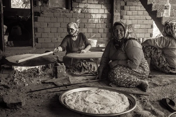 Village women prepare traditional flatbread on an open fire. Turkey — Stock Photo, Image