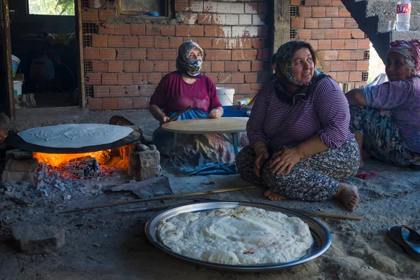 Village women prepare traditional flatbread on an open fire. Turkey — Stock Photo, Image