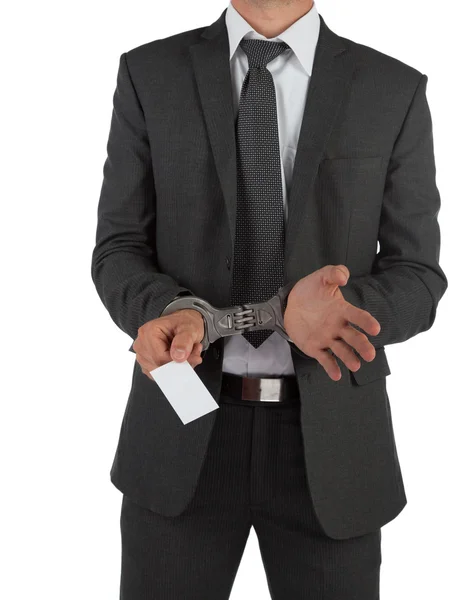 Businessman in suit and handcuffs handing over card — Stock Photo, Image