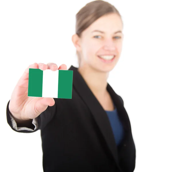 Mujer de negocios sosteniendo una tarjeta con la bandera de Nigeria — Foto de Stock