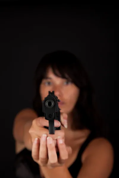 Женщина, целящая пистолет — стоковое фото