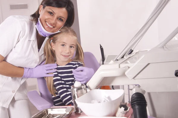 Dentista e paciente em consultório odontológico — Fotografia de Stock