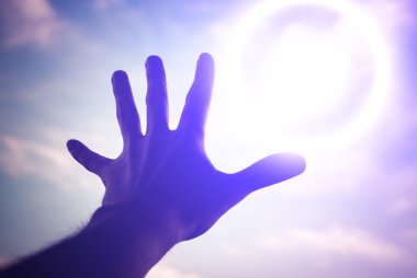 Hand reaching to towards sky.