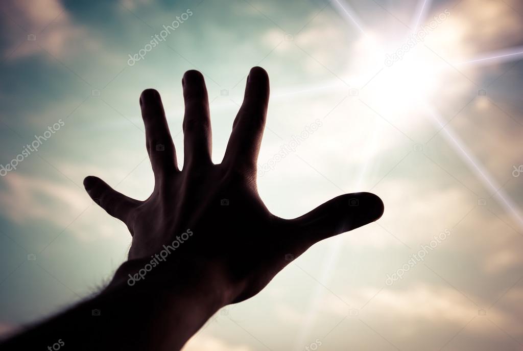 Hand reaching to towards sky.