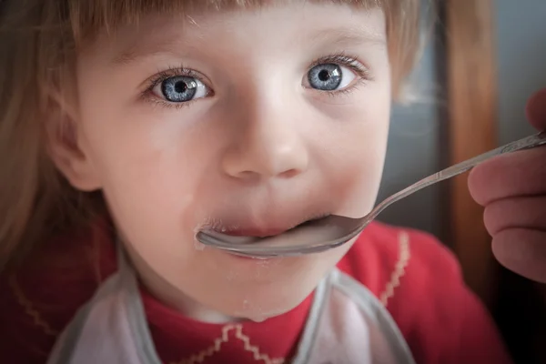 Baby girl being fed by hand. — Stock Photo, Image