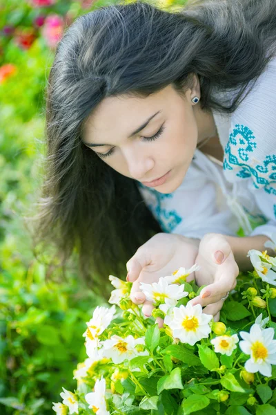 Young girl smelling flowers. — Stock Photo, Image