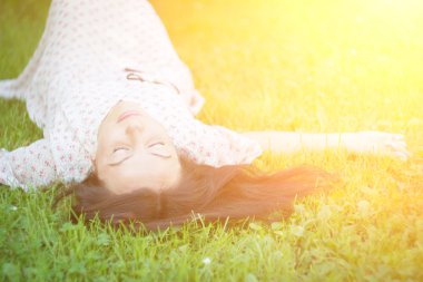 Genç kadın çimlerin üzerinde yatıyor..