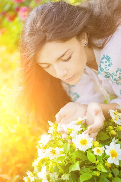 Young woman smelling flowers. — Stock Photo, Image