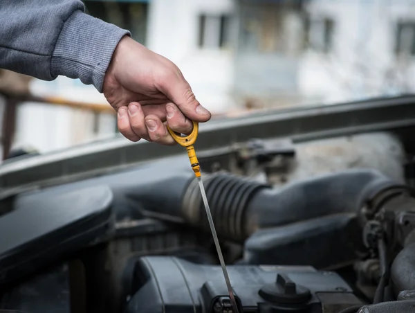 Mechanic checking oil.