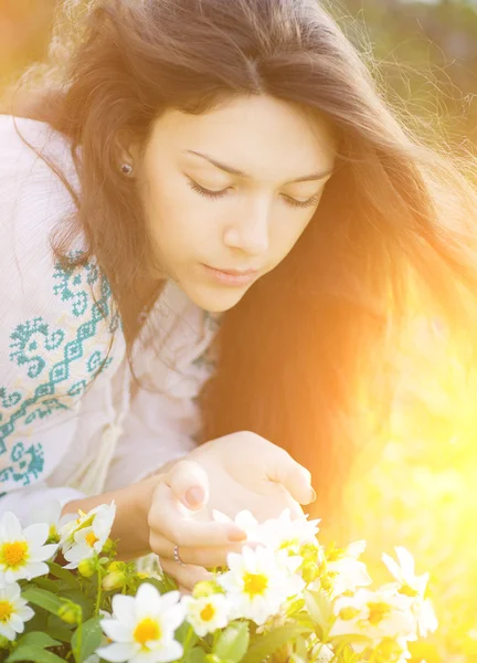 Young woman smelling flowers. — Stock Photo, Image