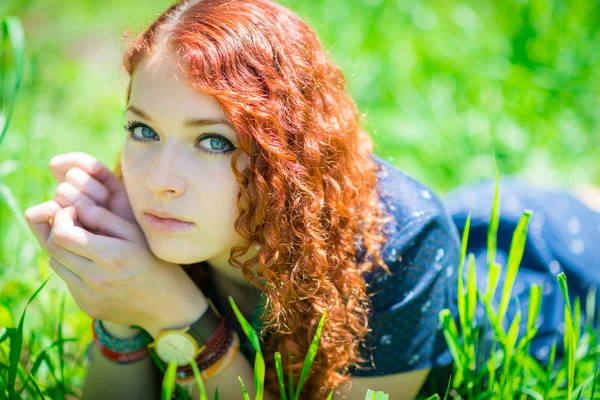 Pelirroja chica yacía en la hierba . — Foto de Stock