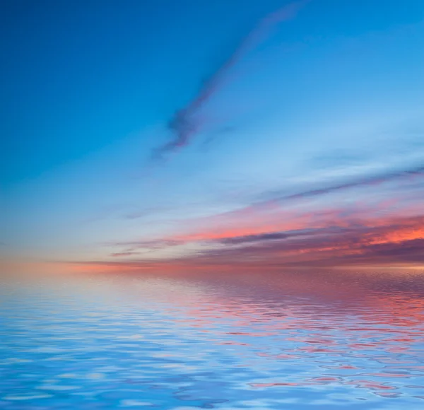 Por do sol refletido na água . — Fotografia de Stock