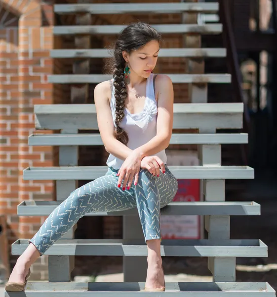 Meisje, zittend op de metalen trap. — Stockfoto