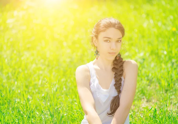 Портрет девушки, сидящей на траве . — стоковое фото