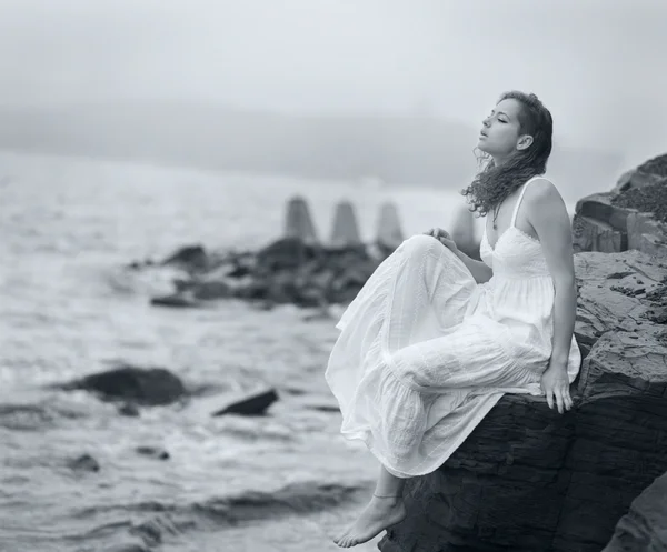 Woman looks into the distance at sea.