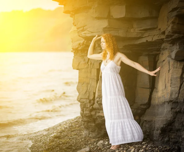 Žena v šatech pohledu k moři. — Stock fotografie