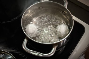 İki beyaz yumurta bir tencerede kaynatılır..