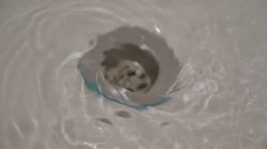 Bir mutfak lavabo deliği aşağı akan su. Seçici odak. 