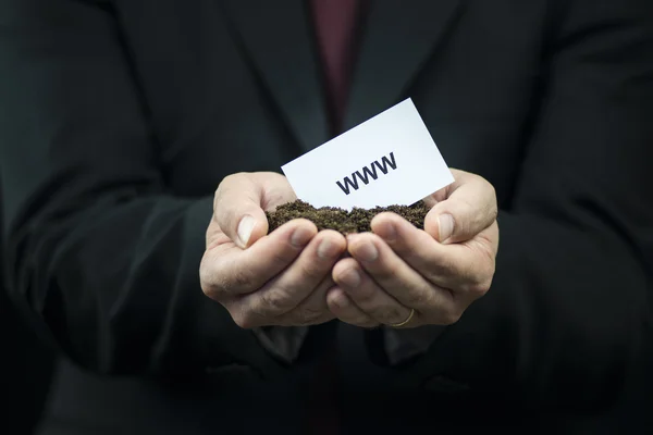 Business card in hands on the ground — Stock Photo, Image