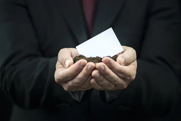 Business card in hands on the ground — Stock Photo, Image