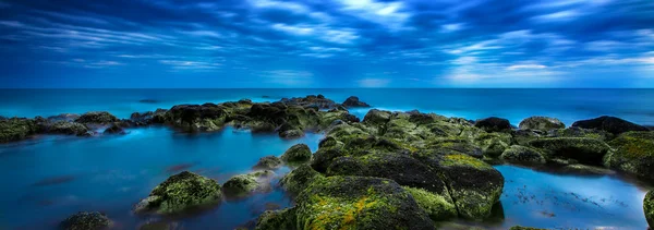 Skymning över lugna blå havet över havet och mulen himmel Royaltyfria Stockbilder