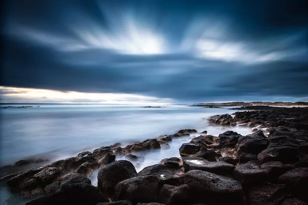 Dramatiska oceanen solnedgång med rullande moln och våg — Stockfoto