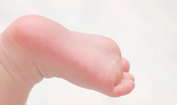 Jambe de bébé sur fond blanc — Photo