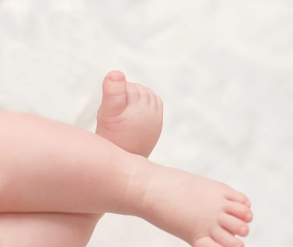 Patas de bebé sobre fondo blanco — Foto de Stock