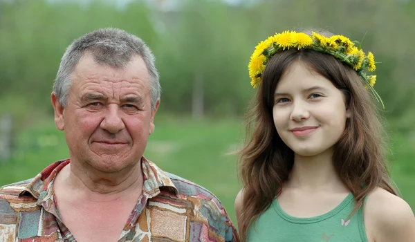 Portrait of beautiful teenage girl with grandfather in country side — Stock Photo, Image