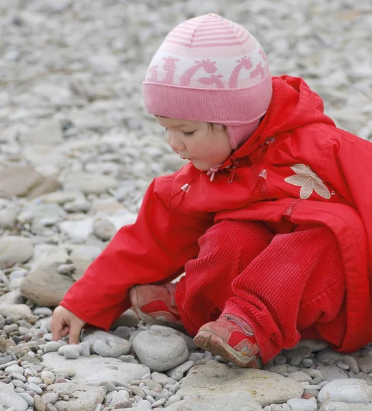 Portret van baby op pebble stenen door de zee — Stockfoto