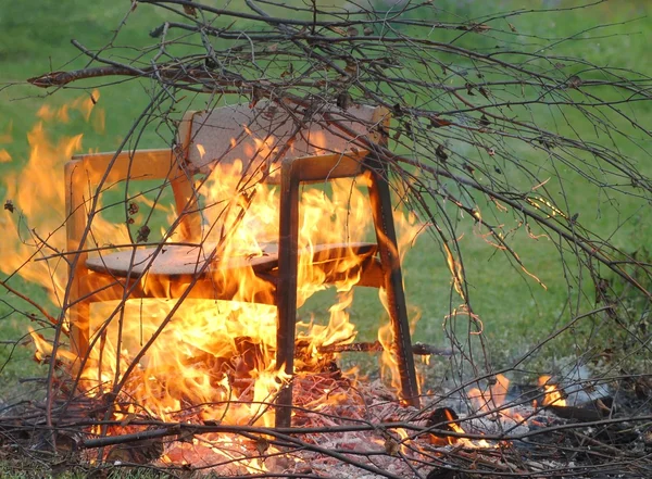 Burning branches and chair — Stock Photo, Image