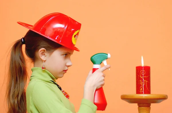 Girl in a fireman helmet with candle — Stock Photo, Image