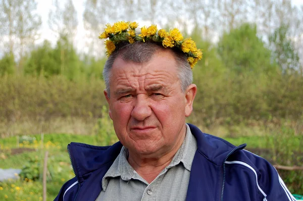 Old men with dandelions wreath — Stock Photo, Image